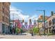 Lively street view of downtown with Colorado and American flags, shops, and pedestrian activity at 1551 Larimer St # 1803, Denver, CO 80202