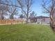 Backyard features artificial grass, patio, seating area, and mature trees at 1140 S Elm St, Denver, CO 80246