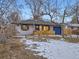 Inviting single-story home with a blue door, natural wood accents, and a well-maintained front yard with mature trees at 1140 S Elm St, Denver, CO 80246