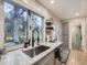Bright kitchen features quartz counters, stainless steel sink, and a window offering outdoor view at 1140 S Elm St, Denver, CO 80246