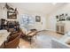 Sunlit living room with hardwood floors, comfortable seating, stylish decor, and a view of the outdoors through a large window at 1140 S Elm St, Denver, CO 80246