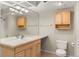 Bright bathroom with a large mirror, wood vanity, and neutral tile floors offering a clean and classic design at 6380 S Boston St # 391, Greenwood Village, CO 80111