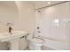 Clean, modern bathroom with white tile, pedestal sink, and bathtub with shower at 647 Skyhook St, Erie, CO 80516