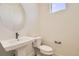 Contemporary half-bathroom with a pedestal sink, toilet, and modern fixtures at 647 Skyhook St, Erie, CO 80516