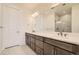 Bright bathroom featuring double vanity with stone countertop and a frameless glass shower at 647 Skyhook St, Erie, CO 80516