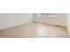 Bright, empty bedroom with light hardwood floors, window and baseboard trim at 647 Skyhook St, Erie, CO 80516