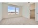 Empty bedroom with large windows overlooking a developed community with view into walk-in closet at 647 Skyhook St, Erie, CO 80516