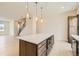 Open kitchen features a large island with breakfast bar, wood cabinets, and modern appliances at 647 Skyhook St, Erie, CO 80516