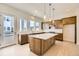 Bright kitchen with a center island, bar seating, and a door leading to the outdoors at 647 Skyhook St, Erie, CO 80516