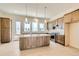 Well-lit kitchen with a large central island, ample cabinet space, and stainless steel appliances at 647 Skyhook St, Erie, CO 80516