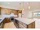 Spacious kitchen with a marble countertop island, stainless steel appliances, and wooden cabinetry at 647 Skyhook St, Erie, CO 80516