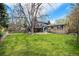 Spacious backyard with green grass, a well-kept lawn, a deck, a patio, and mature trees providing shade at 12175 W 68Th Pl, Arvada, CO 80004