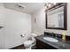 Half bathroom with granite vanity top, modern fixtures, and wood flooring at 12175 W 68Th Pl, Arvada, CO 80004