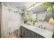 Bathroom featuring a double vanity, large mirror, and green plants at 12175 W 68Th Pl, Arvada, CO 80004