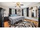 Comfortable bedroom with hardwood floors, neutral walls, a ceiling fan, and large windows with outside light at 12175 W 68Th Pl, Arvada, CO 80004