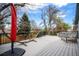 Deck with gray wood flooring featuring an umbrella, hammock, bench, and hot tub at 12175 W 68Th Pl, Arvada, CO 80004