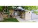 Close-up of the charming home's front entrance with brick facade and well maintained landscaping at 12175 W 68Th Pl, Arvada, CO 80004
