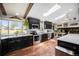 Bright kitchen with stainless appliances, black cabinets, wood floors, a large window, and skylights at 12175 W 68Th Pl, Arvada, CO 80004