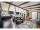 Open-concept living area with hardwood floors, wooden ceiling beams, and seamless flow into the modern kitchen at 12175 W 68Th Pl, Arvada, CO 80004
