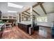 Spacious living room with hardwood floors, wooden ceiling beams, fireplace, and an adjacent modern kitchen at 12175 W 68Th Pl, Arvada, CO 80004