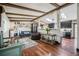 Inviting living room with wood floors, decorative beams, an electric fireplace, and an open view to the kitchen at 12175 W 68Th Pl, Arvada, CO 80004