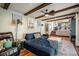 Comfortable living room featuring exposed beams, hardwood floors, a ceiling fan, and blue sectional sofa at 12175 W 68Th Pl, Arvada, CO 80004