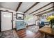 Cozy living room featuring hardwood floors, a decorative fireplace, exposed beams, and a charming blue bench at 12175 W 68Th Pl, Arvada, CO 80004