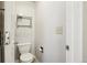 Powder room with a toilet, a metal toilet paper holder, and a metal wall shelf at 17943 E Bates Ave, Aurora, CO 80013