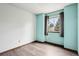 Bedroom with blue accent wall, wood floors, and a window with gray curtains at 17943 E Bates Ave, Aurora, CO 80013