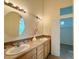 Bathroom featuring a double sink vanity with decorative mirrors and warm lighting at 1688 Aquamarine Dr, Brighton, CO 80603