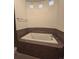 Large soaking tub with tile surround and inset windows for natural lighting at 1688 Aquamarine Dr, Brighton, CO 80603