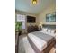 Modern bedroom with large TV, neutral color palette, dresser, and soft, neutral-toned carpet at 1688 Aquamarine Dr, Brighton, CO 80603