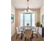 Elegant dining room featuring a glass-top table, modern chairs, and a bay window for natural light at 1688 Aquamarine Dr, Brighton, CO 80603