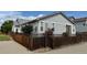 Exterior side view of home with partial fence, landscaping, and ample parking at 1688 Aquamarine Dr, Brighton, CO 80603