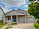 Well-maintained single-story home with a blue front door, covered porch, and a two-car garage at 1688 Aquamarine Dr, Brighton, CO 80603
