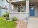 Inviting front porch with decorative landscaping, an ADT security sign, and a clear view of the front door at 1688 Aquamarine Dr, Brighton, CO 80603
