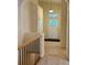 Hallway with stairs leading down to a front door and tiled entryway, complete with transom window at 1688 Aquamarine Dr, Brighton, CO 80603