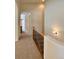 Bright upper-level hallway with carpet flooring and an arched entryway, leading to various rooms at 1688 Aquamarine Dr, Brighton, CO 80603