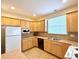 Efficient kitchen layout featuring wood cabinets, updated appliances, and laminate countertops at 1688 Aquamarine Dr, Brighton, CO 80603