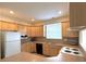 Spacious kitchen featuring white appliances, laminate counters, and ample cabinet space at 1688 Aquamarine Dr, Brighton, CO 80603