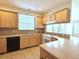 Functional kitchen equipped with wooden cabinets, laminate counters, and black appliances at 1688 Aquamarine Dr, Brighton, CO 80603