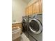 The laundry room features side-by-side washer and dryer, sink, and storage at 1688 Aquamarine Dr, Brighton, CO 80603