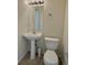 Cozy powder room featuring a pedestal sink, toilet, and stylish mirror, perfect for guests at 1688 Aquamarine Dr, Brighton, CO 80603