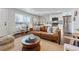 Comfortable living room showcasing a leather sofa, area rug, and a modern kitchen with stainless steel appliances at 1275 Winona Ct # B, Denver, CO 80204