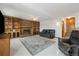 Basement living room features fireplace, built-in shelving, tile flooring, and leather furniture at 11131 Seton Pl, Westminster, CO 80031