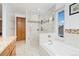 Spacious bathroom featuring a glass shower, a soaking tub, a window, and granite countertops at 11131 Seton Pl, Westminster, CO 80031
