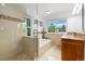Bright bathroom featuring a shower and bathtub, a large window overlooking the backyard, and vanity at 11131 Seton Pl, Westminster, CO 80031