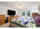 Bright bedroom with a large TV, ceiling fan, and two windows offering scenic neighborhood views at 11131 Seton Pl, Westminster, CO 80031