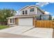 Two-story home with brick and siding, large driveway with garage, and partial wooden fence at 11131 Seton Pl, Westminster, CO 80031