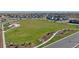 Aerial view of a neighborhood featuring a large central park with mature landscaping and Gathering-friendly amenities at 9886 Ceylon Ct, Commerce City, CO 80022